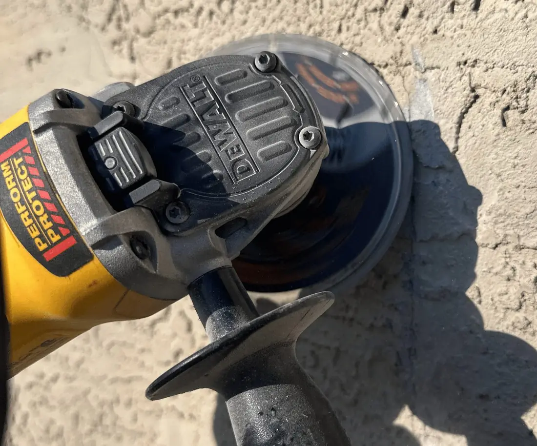 Angle grinder opening up a stucco crack before patching